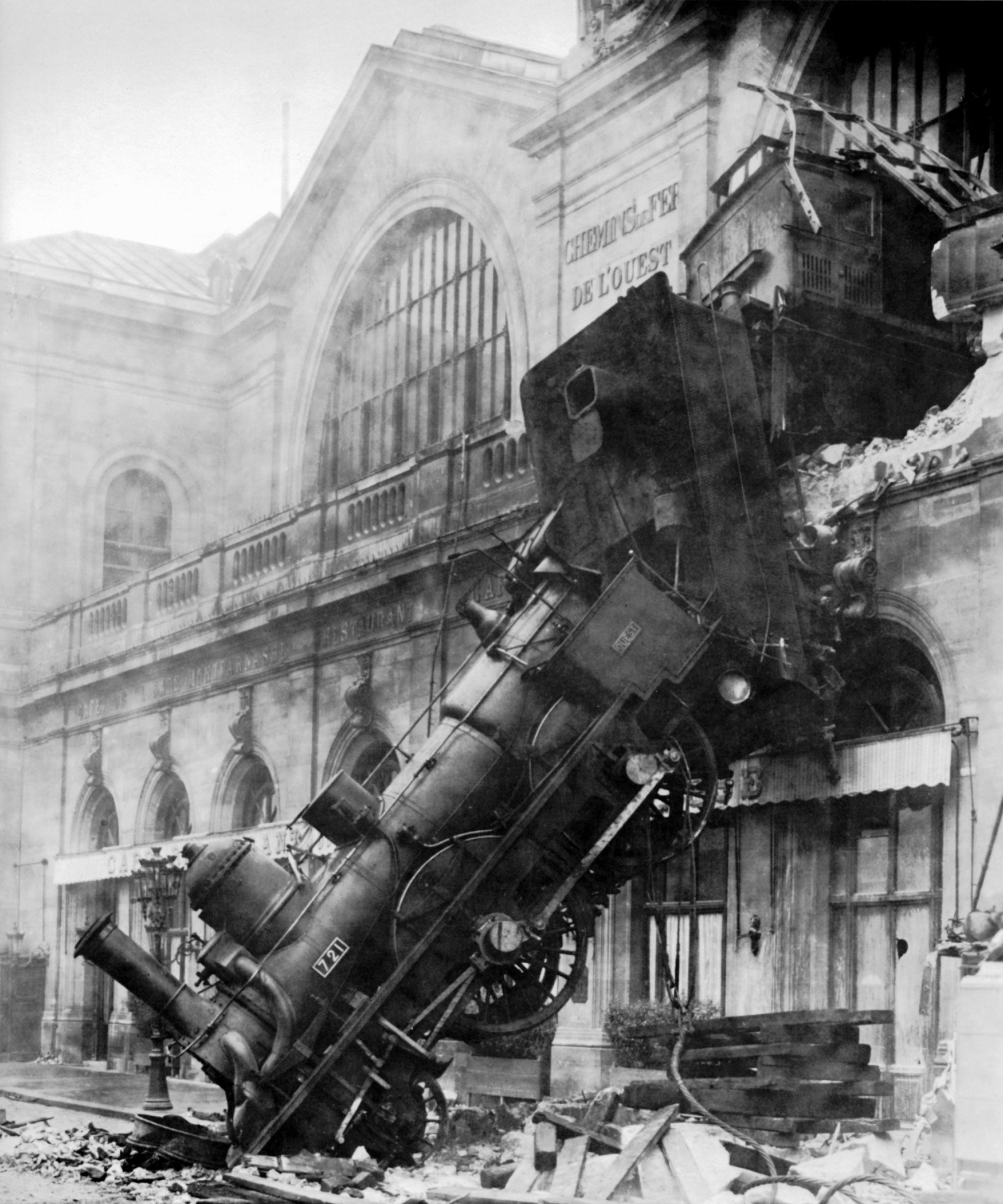 Steam locomotive hanging out of the shattered facade of Gare Montparnasse, 1895
